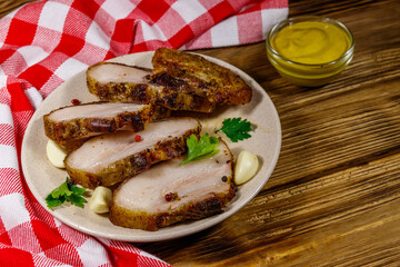 Baked pork belly in a plate on wooden table