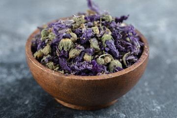 Dried purple flowers in wooden bowl