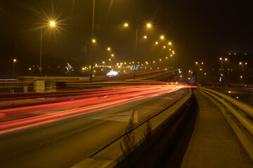 Fototapeta na wymiar Night blurred traffic, light lines, highway bridge