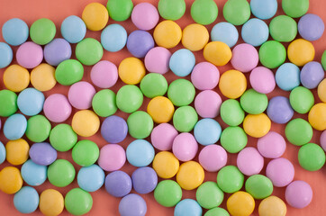 Fototapeta na wymiar Pastel colored candy on an orange background, easter background