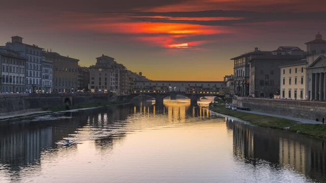 Florence skyline sunset over Ponte Vecchio Florence zoom Timelapse at night and Arno river in Florence Italy City. Reflection on water.