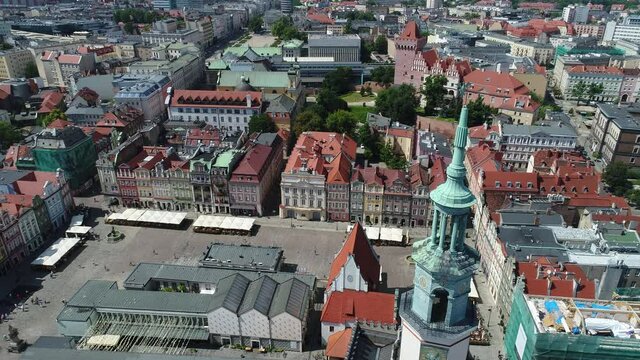 A drone view of most of the Old Market Square in Poznań. Visible colorful historic tenement houses, atmospheric streets and the newer part of the city