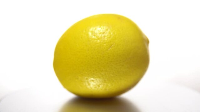 Yellow Lemon with shadow on a white table, rotation 360 degrees. White background.Ultra high definition .