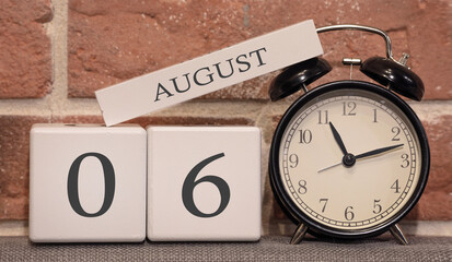 Important date, August 6, summer season. Calendar made of wood on a background of a brick wall. Retro alarm clock as a time management concept.