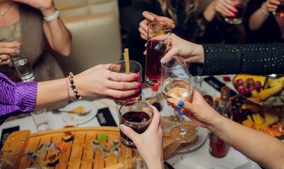 Clinking glasses with alcohol and toasting, party.
