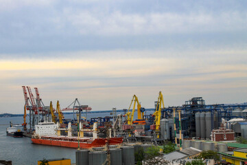 Fototapeta na wymiar Hoisting cranes and industrial ships at cargo sea port in Odessa, Ukraine