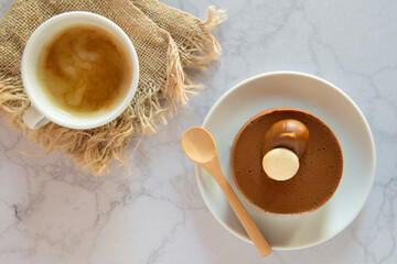 Taza de café acompañada a una postre , vistos desde arriba