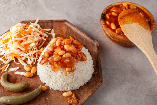 Bean stew over rice pilaf known as Pilav ustu kuru fasulye is a popular dish in Turkey where haricot beans stewed with spice and tomato sauce is transferred on top of butter cooked rice pilau.