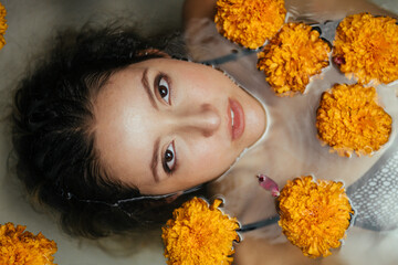 Above the water you can see the face of a girl surrounded by buds of flowers. High quality photo - 416640578