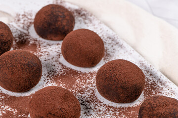 Fine chocolate truffles on white ceramic plate.