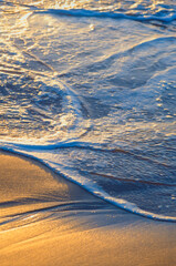 Incoming water rolling onto wet sand