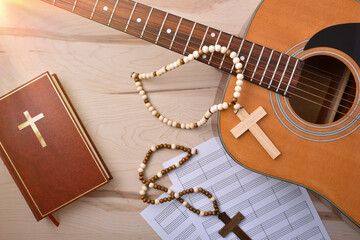 Table with guitar crosses bible and sheet music