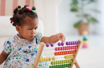 cute african american baby girl playing colorful abacus toy at home - 416642149