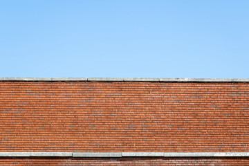 Top of an Exterior Orange Brick Wall with Concrete under a Clear Blue Sky