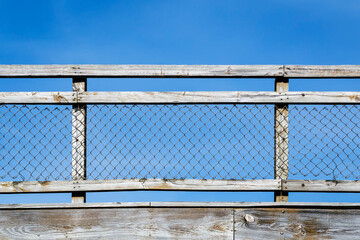 Weathered Wood and Chain Link Fence against a Clear Blue Sky