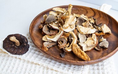 Dried forest mushrooms on wooden plate