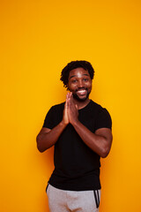 young handsome african american guy student posing cheerful and gesturing on yellow background, lifestyle people concept