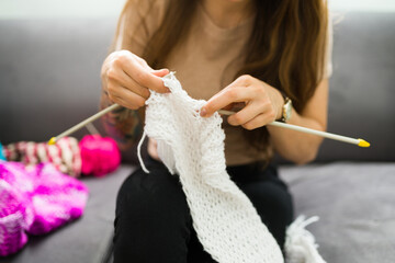 Latin woman learning how to knit winter clothes