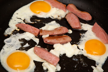 Fried eggs with sausages. We are preparing breakfast.