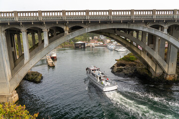 A whale watching boat passing under the concrete arch bridge at Depoe Bay on the Oregon coast