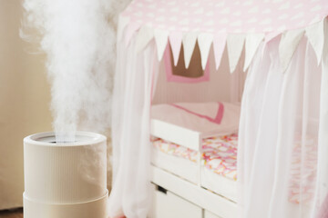 Fototapeta na wymiar Modern air humidifier in children's room, aroma oil diffuser at home. Improving the comfort of living in a house, Improving the well-being. Baby care