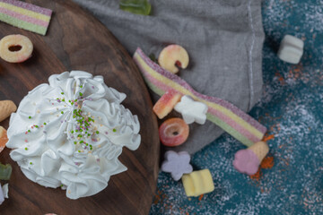 White meringue cookies in a wooden platter with jellybeans around