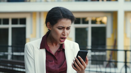 Fototapeta premium Disappointed businesswoman having video chat outside. Woman calling outdoors.