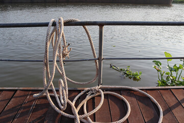 Marine ropes attached to a steel rail at the port closeup.