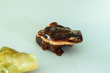 brown frog sculpted in marble on a white background, for decoration