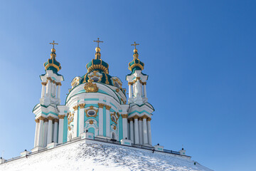 Fototapeta na wymiar Kyiv, Ukraine. View of St. Andrew's Church on the snow-capped St. Andrew's Hill. Stauropegia of the Ecumenical Patriarch in Kyiv. Baroque designed by Rastrelli in 1747