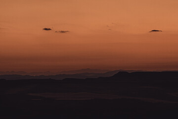 Fototapeta na wymiar Amanecer dorado con montañas a diferentes distancias