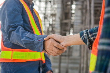 Two Engineer shake hand agreement success project at construction site