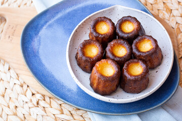 A plate of french pastries, Canelés de Bordeaux with a blue napkin