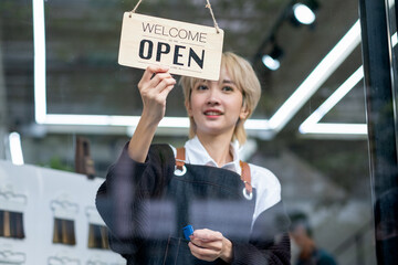 Asian beauty salon barber young girl hold banner of open the shop with smiling. Beauty business for good appearance for people concept.