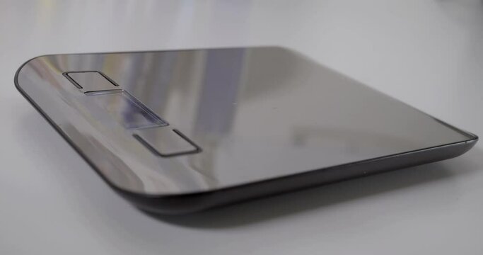 A jeweler weighs a gold necklace using an electronic scale

