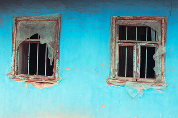 Obraz na płótnie Canvas Old windows and blue wall of abandoned house