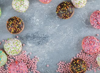 Colorful cookies decorated with sprinkles on marble background