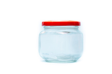 Transparent glass jar with red colour lid on white background.