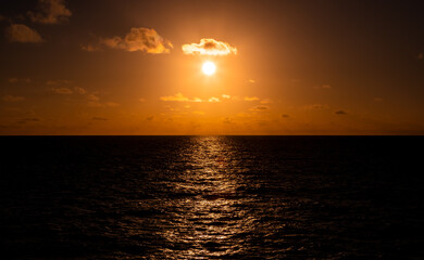 landscapes Beautiful refection orange,gold sunset with clouds over the  Pacific Ocean viewed from an ocean liner.