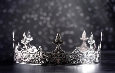 Silver Metal King or Queens Crown on a black Wood Table