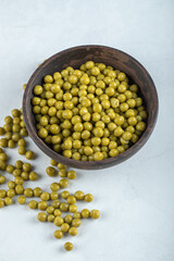 Vertical photo of marinated green olives in wooden bowl
