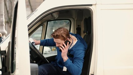 Delivery service man sitting in van and writing documents on clipboard before delivering a package to customer. Checking list, working process.
