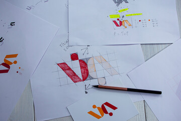 Sketches and drawings of the logo printed on paper. Development of logo design in the studio on a...