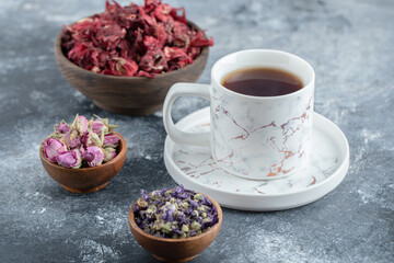 Tea and dried flowers on marble background