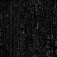 Dark black background of rough burnt wood, soot, and ash. Burn texture. Seamless tile.