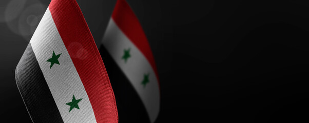 Small national flags of the Syria on a dark background