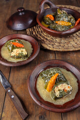 Buntil daun singkong is traditional indonesian food made from cassava leaves Stuffed with grated coconut, petai cina, and anchovy fish. Served on traditional plate