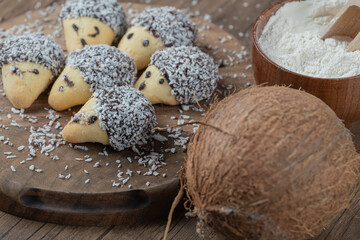 Cone shape cookies with chocolate topping and coconut powder on a wooden board