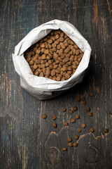 dry nutritious food in granules in a packaging bag on a wooden background