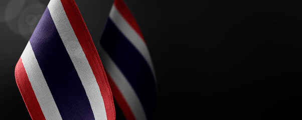 Small national flags of the Thailand on a dark background